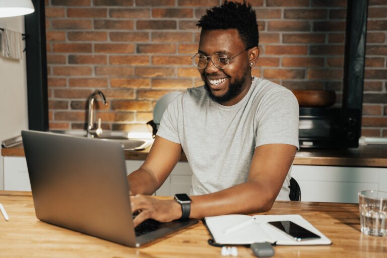 Person smiling, working at computer.